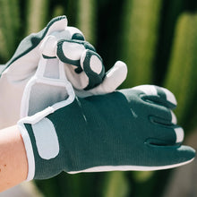 Load image into Gallery viewer, A person adjusting the sprout goatskin gloves in smokey pine in an outdoor setting.