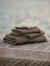 Load image into Gallery viewer, Stack of towels on a wooden surface with a blurred natural background